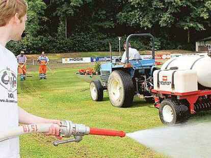 Gro&szlig;einsatz: Nils Schl&uuml;ter (vorn) w&auml;ssert den Rasen; im Hintergrund bringt Heiner Garms die Nematoden ein.