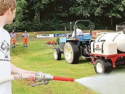 Gro&szlig;einsatz: Nils Schl&uuml;ter (vorn) w&auml;ssert den Rasen; im Hintergrund bringt Heiner Garms die Nematoden ein.