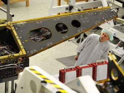 Astrium-Mitarbeiter und Mechaniker Josef Sauermann kontrolliert den ersten von drei Erdbeobachtungssatelliten, die das Raumfahrtunternehmen Astrium fertig gestellt hat.