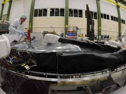 Ein Mitarbeiter des Satellitenbauers Astrium arbeitet in Friedrichshafen am Bodensee im Reinraum an einem der drei Satelliten der Mission 