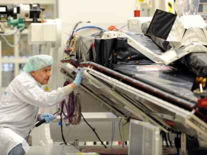 Mechaniker Wolfgang Hege kontrolliert am Dienstag (19.10.10) in Immenstaad den ersten von drei Erdbeobachtungssatelliten, die das Raumfahrtunternehmen Astrium in Immenstaad am Bodensee fertig gestellt hat. Die Swarm-Mission der europaeischen Weltraumorganisation ESA wird die bislang genaueste Vermessung des Erdmagnetfeldes und seiner Veraenderungen vornehmen. Foto: Felix Kaestle/dapd