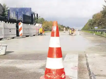 Auf Tuchf&uuml;hlung: Ganz nah fahren die Lastwagen an den Arbeitern vorbei. Unten: Dieter Schmidt stellt ein Frisch betoniert-Schild auf.