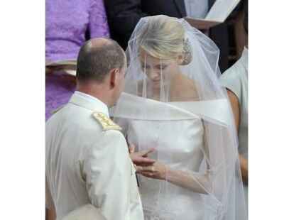 Albert steckt seiner Charlene den Trauring an den Finger.