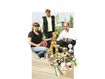 Nadja Drobotova, Hundetrainerin Sabine Botschek und Hubert Zumbr&auml;gel (v.l.) pr&auml;sentieren stolz die Troph&auml;en, die Terry in seiner Laufbahn bereits errungen hat.