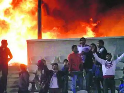 &Auml;gyptische Jugendliche stehen im Stadion der nord&auml;gyptischen Stadt Port Said direkt vor den Flammen. Bei den Ausschreitungen kamen mehr