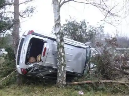 Ein Auto lehnt am Mittwoch an der Autobahn 27 bei Langen (Landkreis Cuxhaven) an einem Baum. Der  72-j&auml;hrige Fahrer war mit seinem Pkw von der Fahrbahn abgekommen. Das Fahrzeug stie&szlig; gegen einen Baum, wurde in die Luft katapultiert und von zwei weiteren B&auml;umen gestoppt. Bild: dpa