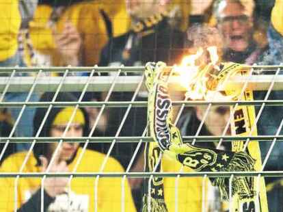 Dresdner Entgleisung in Dortmund: Randalierende Dynamo-Fans z&uuml;ndeten w&auml;hrend des DFB-Pokalspiels BVB-Schals am Zaun an. Die Partie wurde 15 Minuten sp&auml;ter angepfiffen.