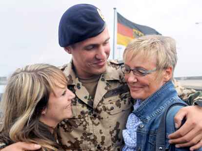 Der Hauptgefreite Sven J&ouml;rns aus Kiel h&auml;lt  an Bord der Fregatte &bdquo;Bremen&ldquo;  seine Freundin Anika Gottschalk (l.) und seine Mutter Angelika Jansen zur Begr&uuml;&szlig;ung in den Armen.