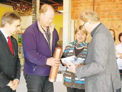 Sven Ambrosy, Frank Neuhaus, Heike Neumann und Hartmut Kapels (von links) f&uuml;llten den Metallbeh&auml;lter f&uuml;r die Grundsteinlegung.