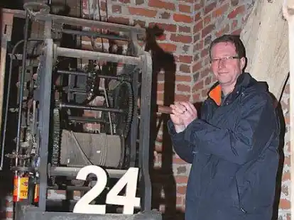 Hat hinter verschlossenen T&uuml;ren viele Jahre &uuml;berdauert: Pfarrer J&uuml;rgen Menzel demonstriert, wie das alte Uhrwerk im Turm der St.-Ansgari-Kirche in Kirchhatten funktioniert.