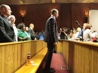 Sprintstar  Oscar Pistorius (rechts) bei seiner Anh&ouml;rung vor dem Magistratsgericht in Pretoria, hinter ihm sein Bruder  Carl  und sein  Vater Henke Pistorius.