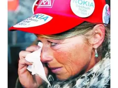 Eine Nokia-Mitarbeiterin wischt sich w&auml;hrend der Kundgebung in Bochum Tr&auml;nen aus dem Auge. Rund 15 000 Menschen demonstrierten f&uuml;r den Erhalt der Arbeitspl&auml;tze.