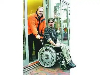 Stolperkante: Heinrich Weymann hilft einem Kunden im Rollstuhl in die B&auml;ckerei.