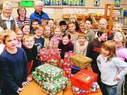 Die Klasse 3a der Grundschule Metjendorf mit Lehrerin Ute Roeder (hinten Mitte) sowie Karin und Frerich Jan&szlig;en vom Awo-Ortsverein Metjendorf. Auch die 4a hatte flei&szlig;ig P&auml;ckchen f&uuml;r Kinder in Osteuropa gepackt.