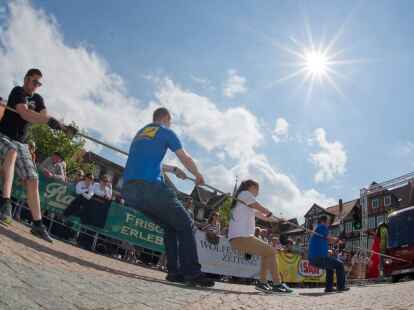 Ein Team zieht  beim Buspulling einen Reisebus &uuml;ber den Stadtplatz in Wolfenb&uuml;ttel.