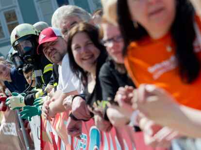 Ein Feuerwehrmann mit Atemschutz hat sich  beim Buspulling in Wolfenb&uuml;ttel unter die Zuschauer gemischt.