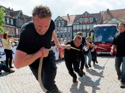 Ein Team zieht beim Buspulling einen Reisebus &uuml;ber den Stadtplatz in Wolfenb&uuml;ttel. Bei den 11. Deutschen Meisterschaften im Buspulling ziehen Teams mit f&uuml;nf Personen mit Hilfe eines Taus einen Reisebus.