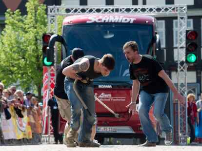 Ein Team zieht beim Buspulling einen Reisebus &uuml;ber den Stadtplatz in Wolfenb&uuml;ttel.