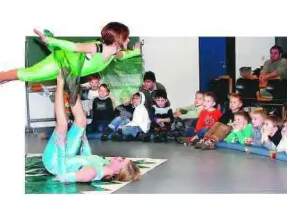 Gebannt starren die Nachwuchsfu&szlig;baller vom FC Hude auf die Darbietungen des kleinen Zirkus. Anna und Emma f&uuml;hren Akrobatikst&uuml;cke auf und beziehen auch die Kinder mit ein.