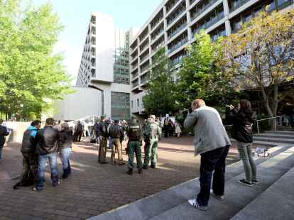 Journalisten und Polizisten stehen vor dem Gerichtsgeb&auml;ude in M&uuml;nchen.