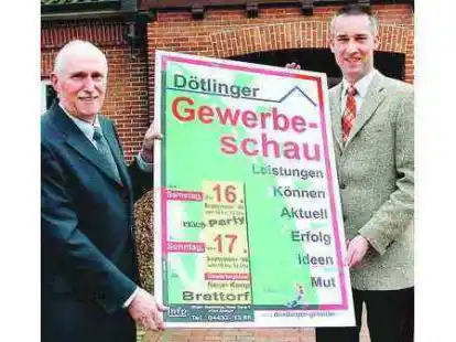 Pr&auml;sentieren das klar gegliederte Plakat zur Gewerbeschau: J&uuml;rgen Hasselberg (links) und D&ouml;tlingens B&uuml;rgermeister Heino Pauka.