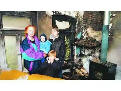 Heimatlos: Petra Naujoks mit ihren drei Kindern Lennox, Aaron und Jimmy in ihrem ausgebrannten Wohnzimmer.