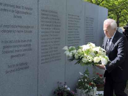 Bahnchef R&uuml;diger Grube legt an der Mauer mit den Namen der Opfer in Eschede ein Blumengesteck nieder.
