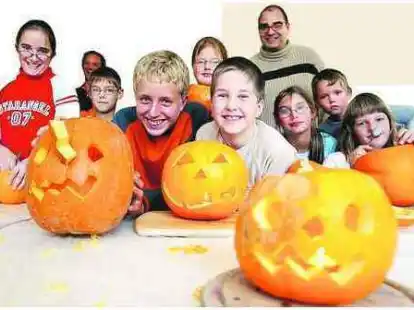 Lachende Kinder und gruselige K&uuml;rbisse: Bei der Ferienpass-Aktion im &bdquo;Trend&ldquo; hatten alle Beteiligten viel Spa&szlig; &ndash; auch Mitarbeiter Matthias Heil (4.v.r.), Michael Fleischer (4.v.l.) und sein Betreuer Gerd von Seggern (im Hintergrund, 2.v.l.).