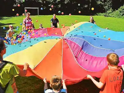 Da fliegen die bunten B&auml;lle: Beim Popcorn-Spiel mit Schwungtuch wurde die &bdquo;Herdplatte&ldquo; immer hei&szlig;er, so dass die Plastikkugeln sich mit viel Schwung &uuml;ber die ganze Wiese verteilten.