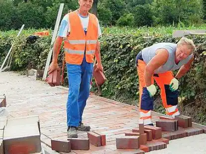 Johann Ueberacher (links) und Martin Willms verlegen die Steine auf dem neuen B&uuml;rgersteig an der B 437.