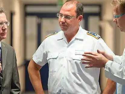 Verteidigungsminister Thomas de Maizi&egrave;re l&auml;sst sich  im Bundeswehrkrankenhauses Westerstede von Oberfeldarzt Lutz Bernsen, Dr. Matthias Haut und Oberstarzt Dirk Possel (v.l.) die Zusammenarbeit zwischen milit&auml;rischem und zivilem Personal erkl&auml;ren.