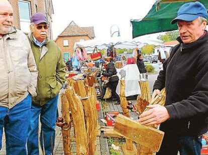 Fachsimpelei unter M&auml;nnern: Franz-Josef Bahlmann (gro&szlig;es Bild, rechts) erkl&auml;rt Besuchern des Herbstmarktes, wie er aus Zaunpf&auml;hlen dekorative Gartenelemente bastelt. K&uuml;rbisse schnitzte auf Gloysteins Hof Karina Cooper.