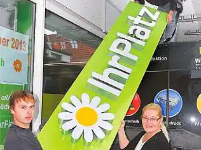 Raffael Thiel (links) und Florian Schwesig brachten das neue Reklameschild an dem Drogeriemarkt in der Fu&szlig;g&auml;ngerzone an, den Jutta Ungruhe im November er&ouml;ffnet.
