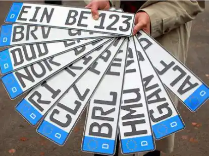 ARCHIV - Ein Mann h&auml;lt am 15.11.2012 vor der Zulassungsstelle in Einbeck (Niedersachsen) die KFZ Kennzeichen mit alten Buchstabenkombinationen in der Hand. Immer mehr Autos sind mit den Retro-Kennzeichen unterwegs. Foto: Hubert Jelinek/dpa (zu lni 