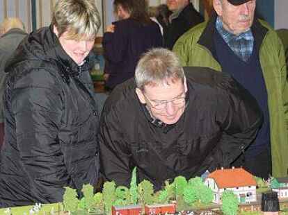 Liebevoll und and&auml;chtig ruht der Blick dieser beiden G&auml;ste auf dem Modell des Burhaver  Bahnhofs. Auch diese Anlage hat ein Bahn-Freund originalgetreu nachgebaut.