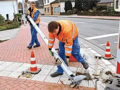Wieder aufgerichtet: Gegen sieben Uhr morgens lag die Ampel noch an der Stra&szlig;e (kleines Bild), am Vormittag  stellten die Verkehrstechniker Manfred Cibotrai und Dominik Evers  bereits Ersatz auf.