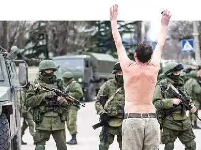 Nackter Protest: Ein Mann  steht oberk&ouml;rperfrei vor Uniformierten in der  ukrainischen Stadt   Sewastopol. Ein Wappen auf einem der Reifen der Panzer identifiziert  die Soldaten als Einsatzkr&auml;fte des russischen Milit&auml;rs.