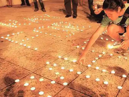 Angeh&ouml;rige z&uuml;nden Kerzen an und beten f&uuml;r die Insassen des vermissten Flugzeugs.