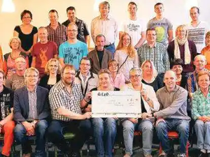 Scheck&uuml;bergabe: Bei der Dankesch&ouml;n-Party wurde das Geld symbolisch &uuml;berreicht. Dazu trafen sich das gro&szlig;e Helferteam und (ab vordere Reihe 4. von links)  Eibe Ruth, Wilfried Wilken, Tanja Otto, Petra Brundiers sowie Ingo Otto.