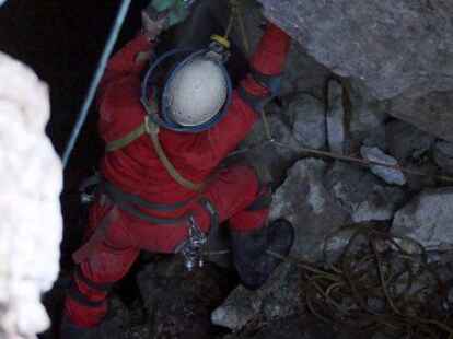 Ein H&ouml;hlenretter seilt sich in rund 1800 Metern H&ouml;he am Eingang der H&ouml;hle ab.