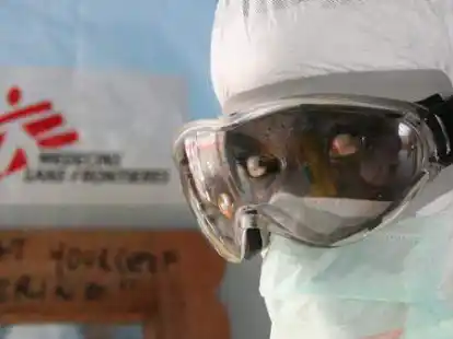 Ein Mitarbeiter von &Auml;rzte ohne Grenzen/Medecins Sans Frontieres (MFS), steht   in Schutzkleidung vor dem Ebola Zentrum der Hilfsorganisation in Monrovia, Liberia.