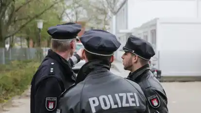 Polizisten besprechen sich vor der Au&szlig;enstelle der Nelson-Mandela-Stadtteilschule.