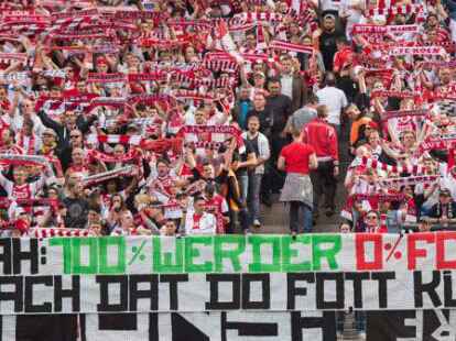 K&ouml;lner Fans stehen vor dem Spiel hinter einem Plakat mit der Aufschrift &bdquo;Ujah 100% Werder 0% FC Mach Datt Do Fott K&uuml;ss!&ldquo;.