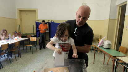 Auch um ihre Zukunft geht es: Ein kleines M&auml;dchen steckt den Stimmzettel ihres Vaters in die Wahlurne.