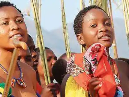 <p> Junge Frauen mit Schilfrohr tanzen in traditionellen Kost&uuml;men und barbusig vor dem K&ouml;nig.  </p>