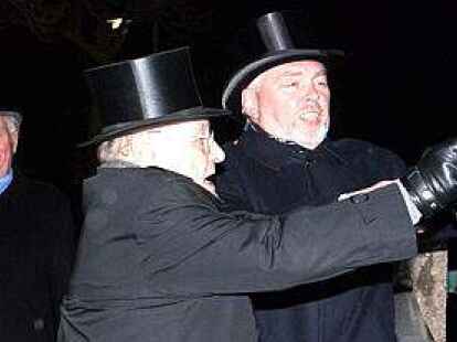 Das Eis fliegt: Um zu testen, ob die Hunte &bdquo;geiht oder steiht&ldquo;, schleudern zwei Wetter eine Eisscholle auf die Hunte und werden dabei von den Mitstreitern beobachtet.