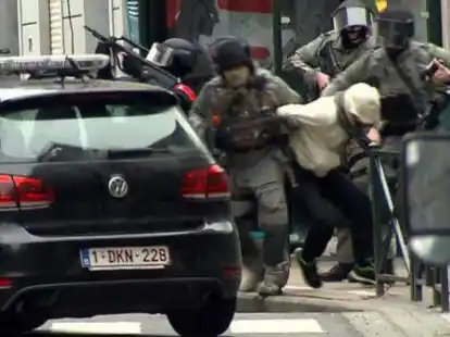Polizisten nehmen einen Verd&auml;chtigen in Molenbeek fest.