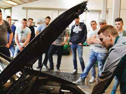 Kostenloser Safety Check an der BBS Technik: Johann Morasch (rechts) von der Dekra erkl&auml;rt den Auszubildenden, was w&auml;hrend der Hauptuntersuchung am Auto kontrolliert wird.