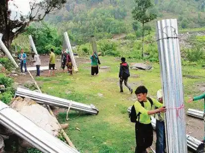 Schwieriger Transport: F&uuml;r den H&auml;userbau wird vor allem Wellblech ben&ouml;tigt. Dieses wird aufgerollt und von den  Nepalesen auf dem R&uuml;cken in die Berge geschleppt.