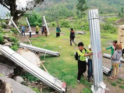 Schwieriger Transport: F&uuml;r den H&auml;userbau wird vor allem Wellblech ben&ouml;tigt. Dieses wird aufgerollt und von den  Nepalesen auf dem R&uuml;cken in die Berge geschleppt.